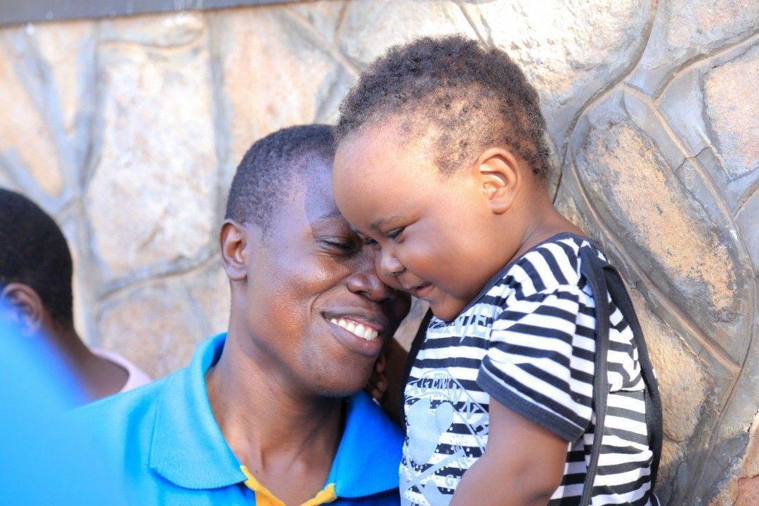 A father and son share a smile during childhood cancer care at New Hope Children's Hostel.