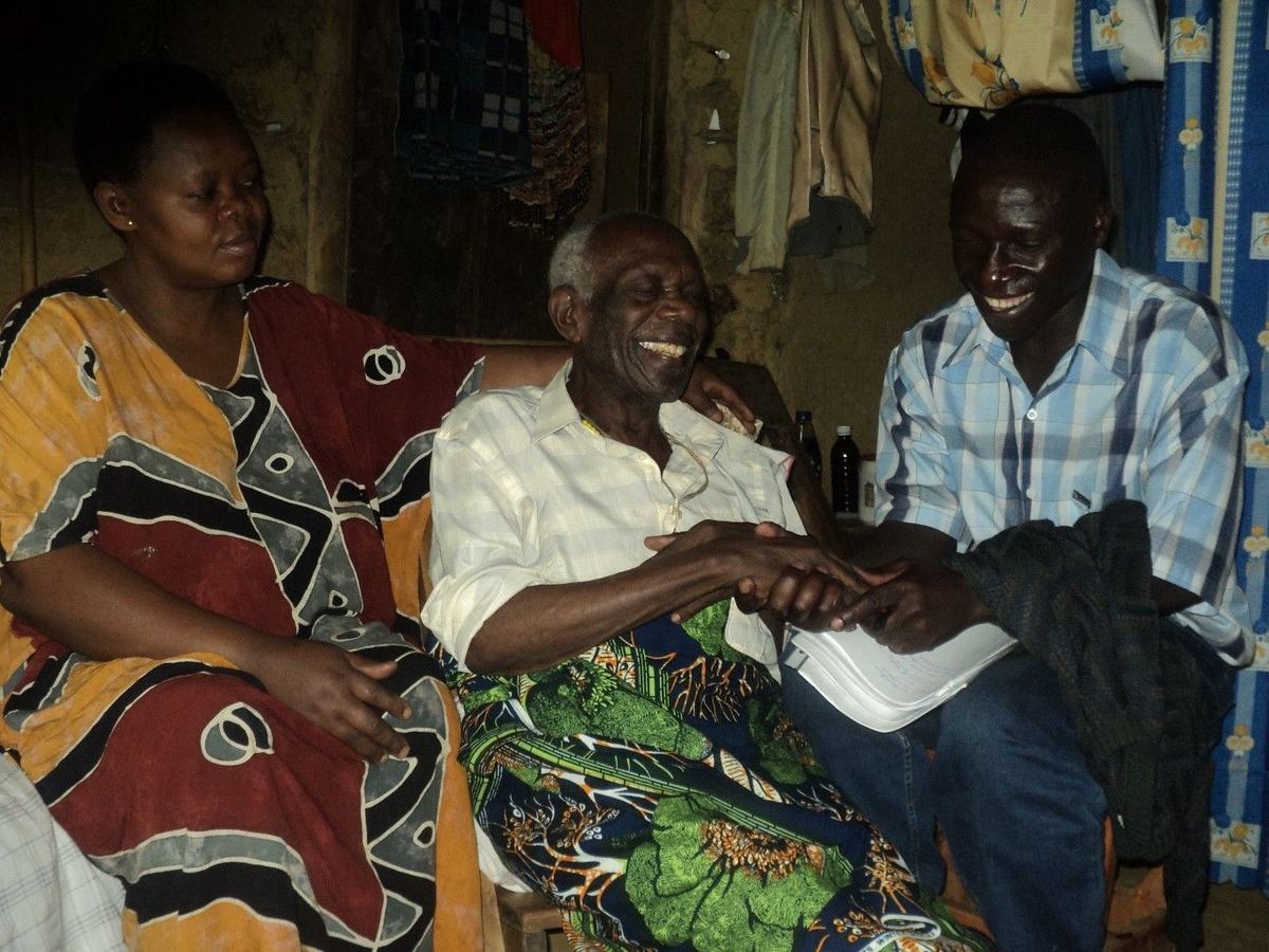 In Bundibugyo, a patient welcomes the home care team and enjoys talking with his visitors.