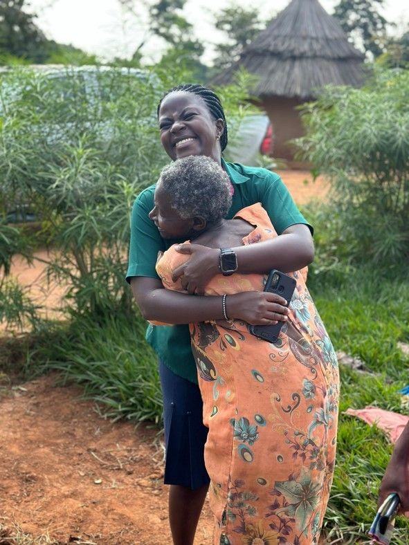 A patient greets a social worker with an embrace during a home visit.