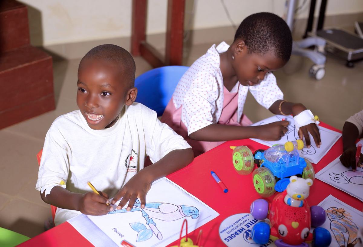 Children draw and play with materials provided during a visit to the paediatric oncology ward.