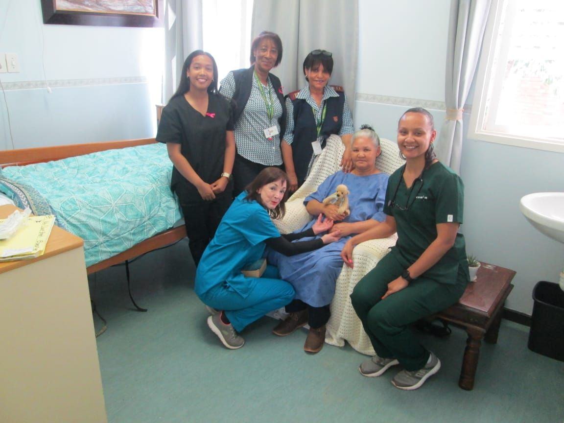 Nurses, a doctor, a social worker and a spiritual counsellor gather to support a patient.