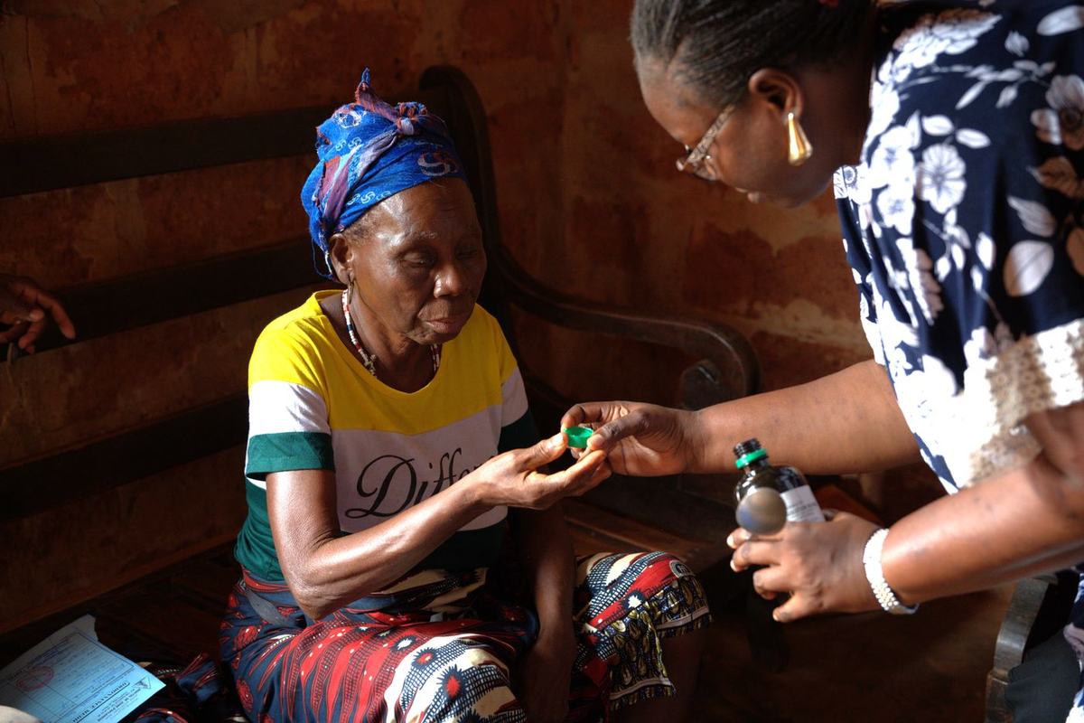 During a home visit in Benin, a nurse explains morphine treatment to a patient.