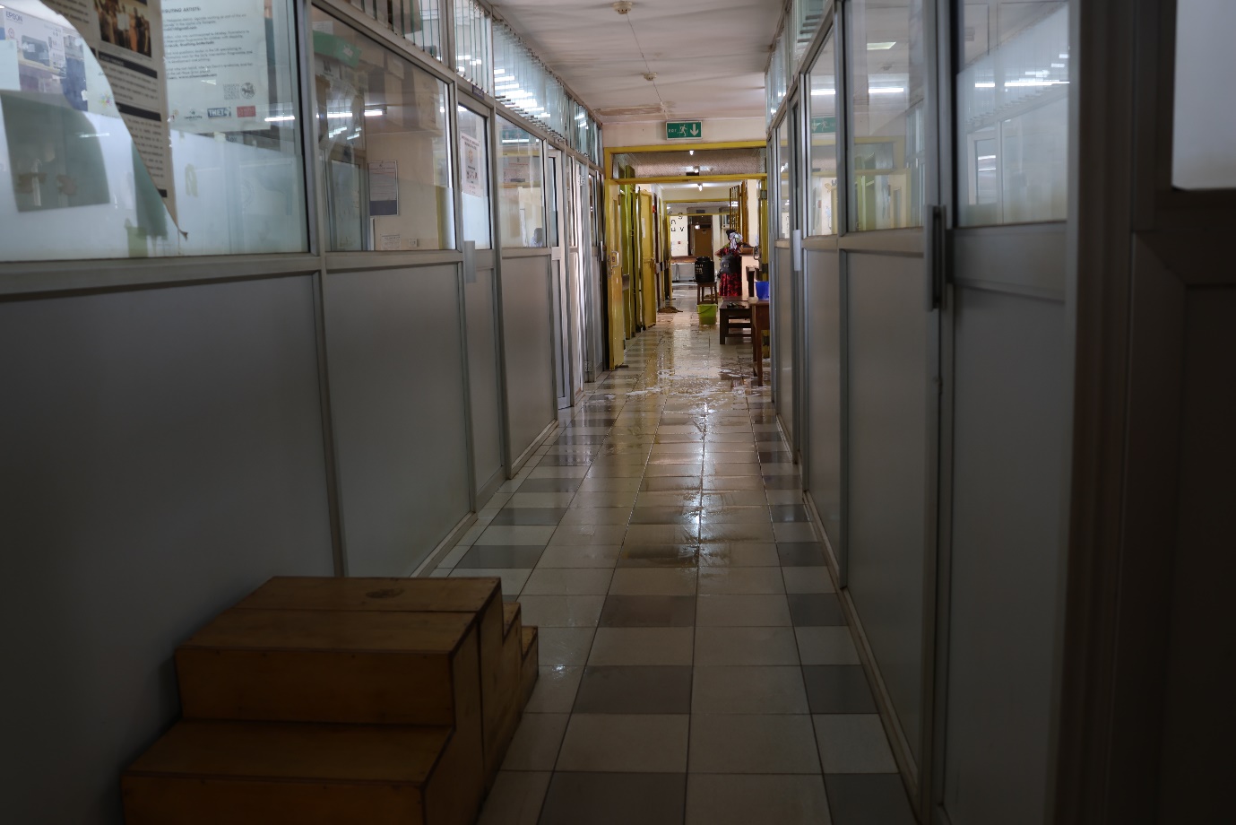 A hallway with glass doors and a tile floor

AI-generated content may be incorrect.